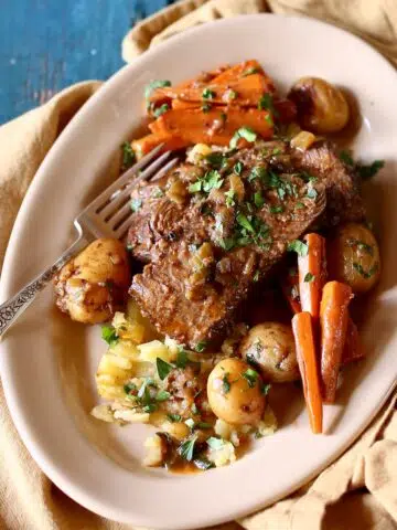 a square photo of pot roast on a plate.