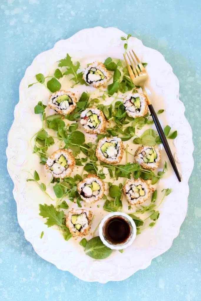 a white platter of sushi rolls.