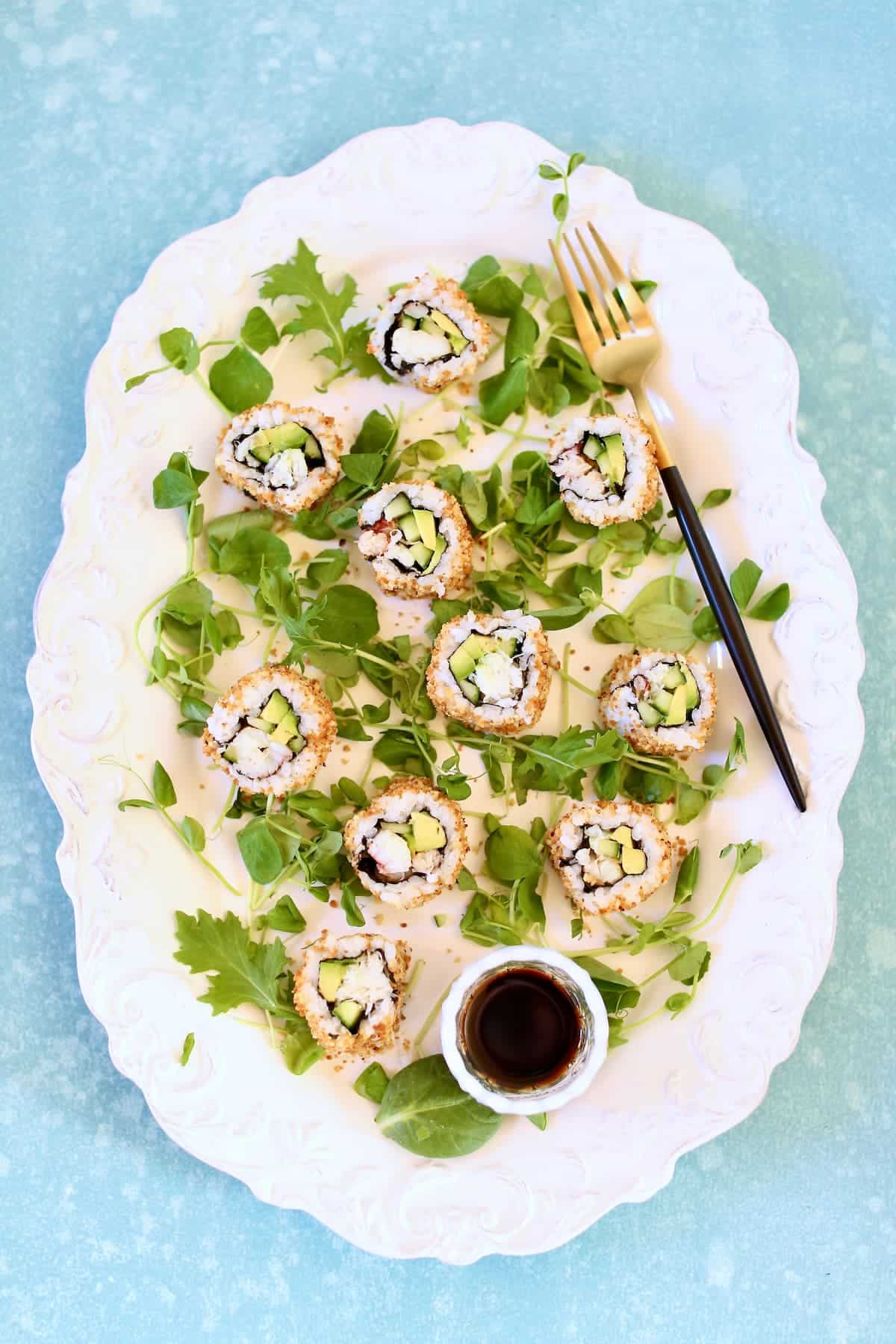 a white platter of sushi rolls.  