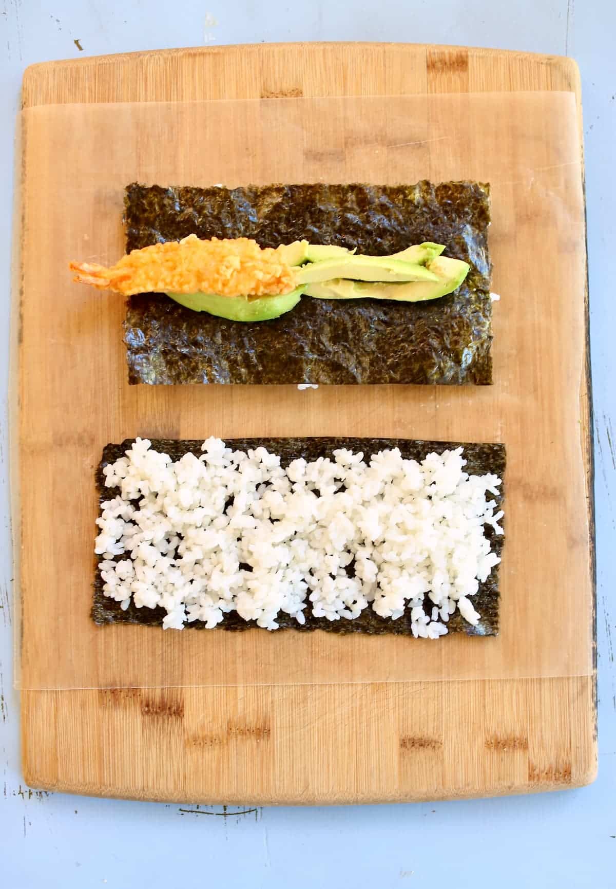 two sushi rolls on a cutting board.