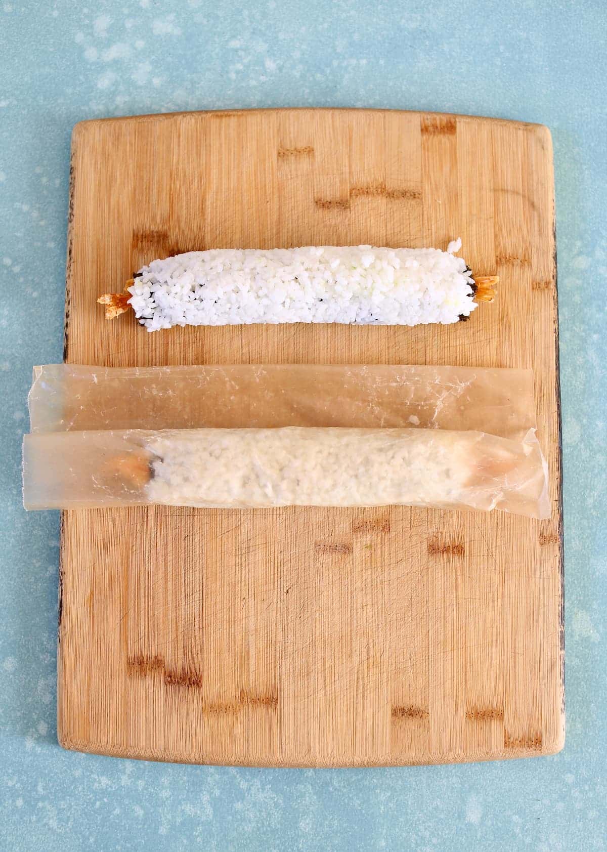 two sushi rolls on a cutting board.