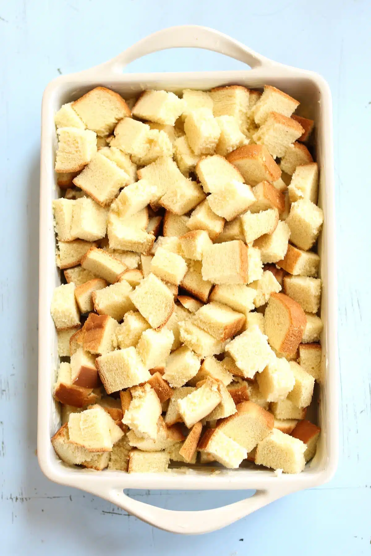 a casserole dish of brioche that is cubed.
