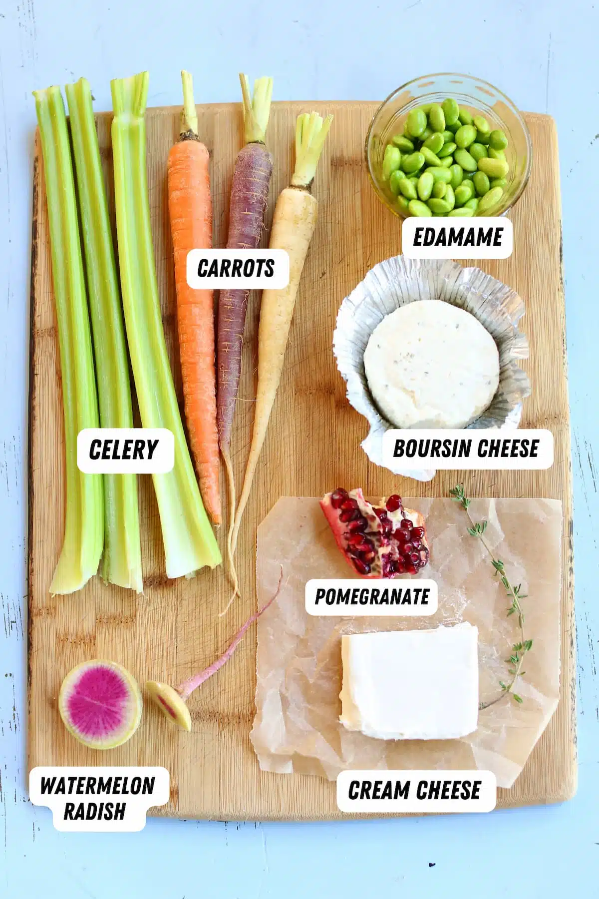 a cutting board with ingredients for a veggie board.