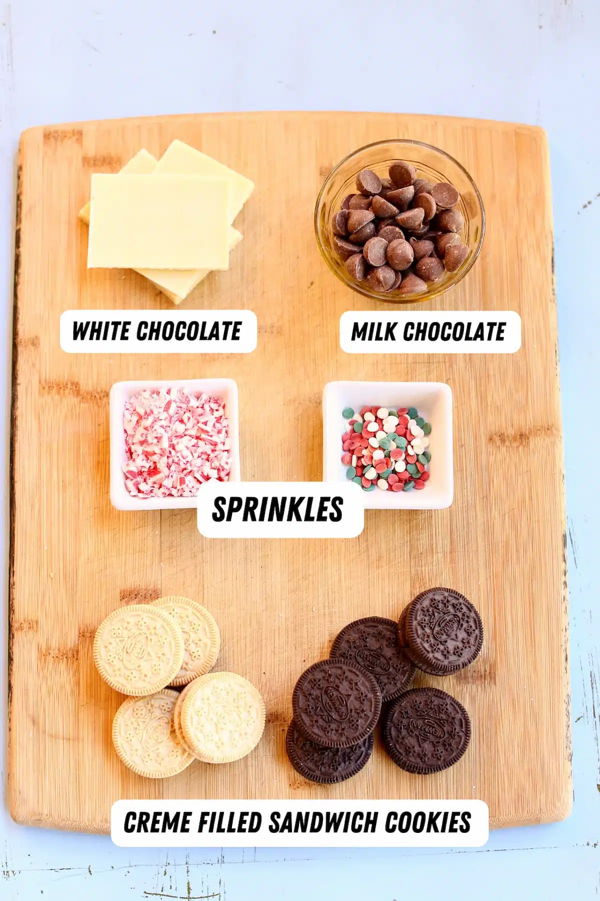 a cutting board with ingredients to make chocolate dipped oreos.  