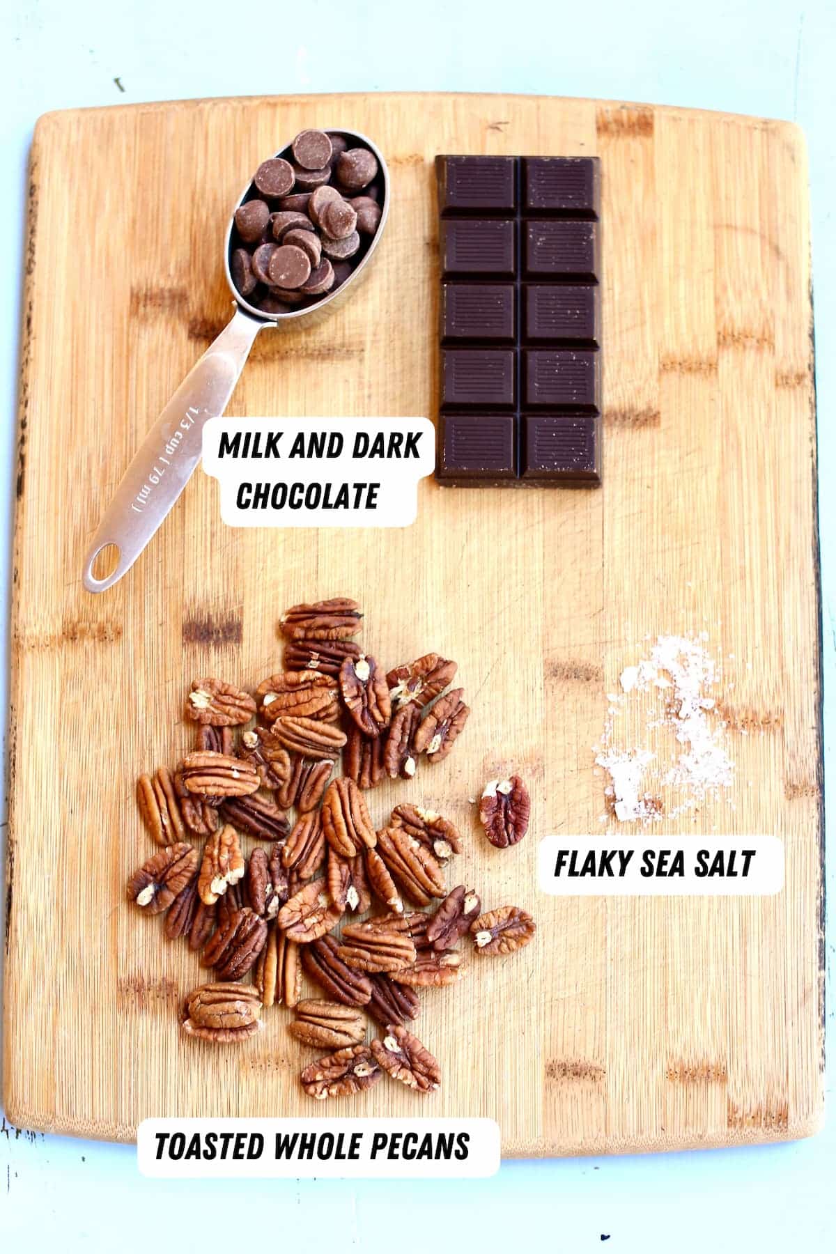 a cutting board with ingredients for chocolate covered pecans.