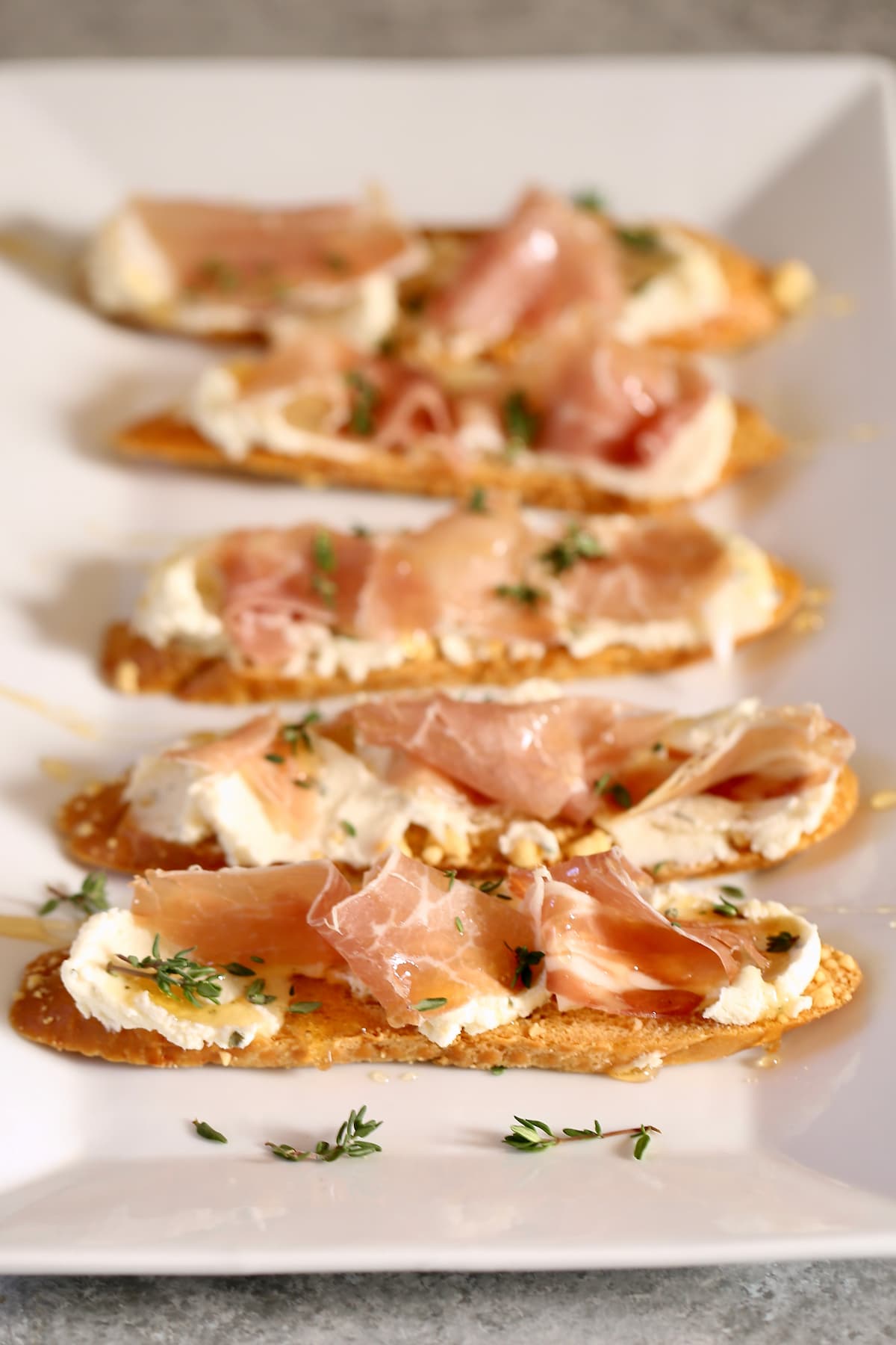 a close up photo of appetizer toasts with prosciutto.