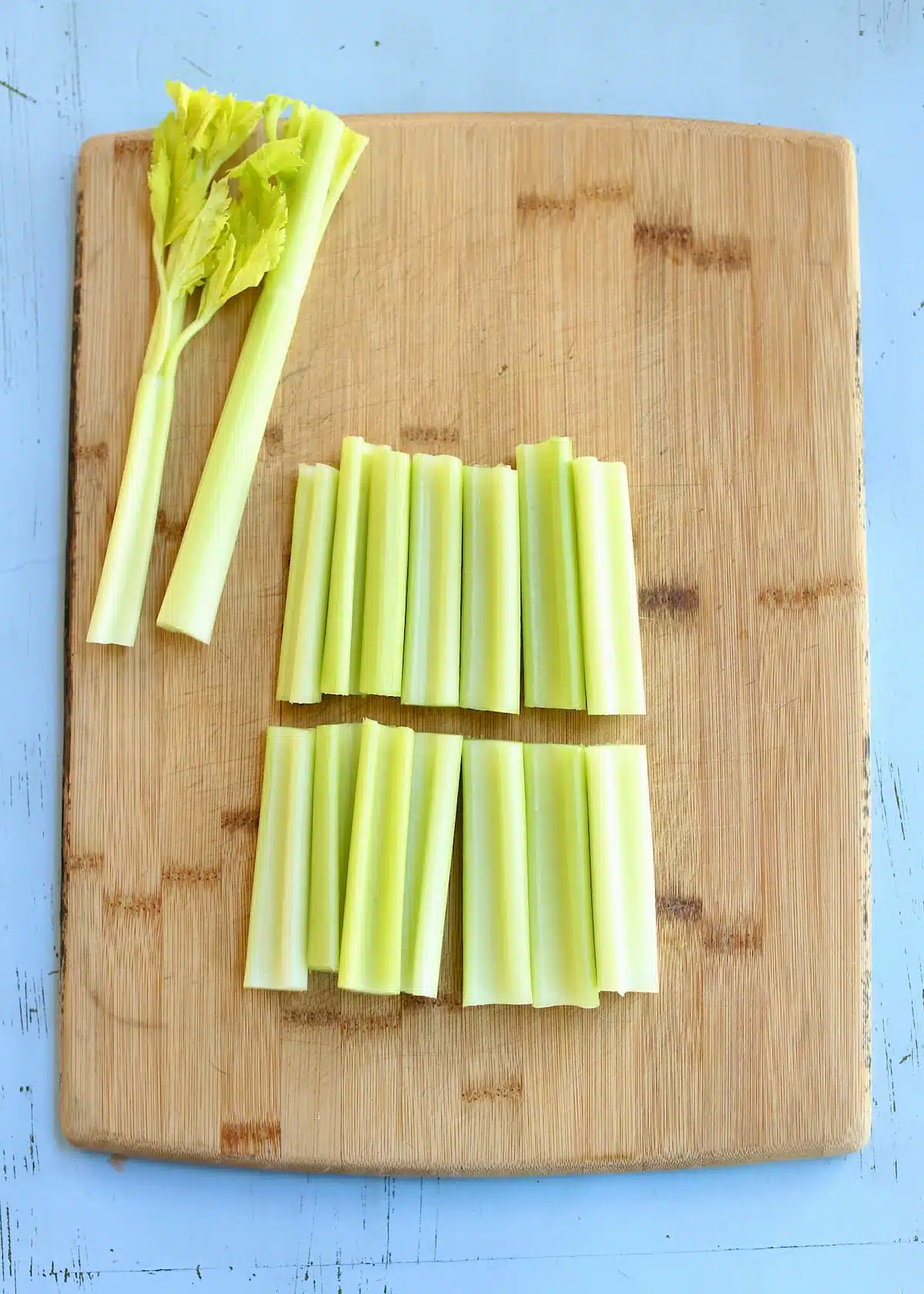 a cutting board with celery cut in half on it.