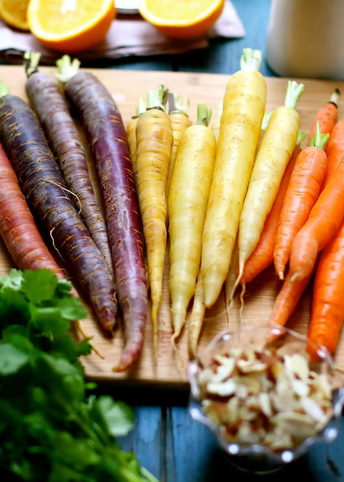 a cutting board with different varieties of carrots.  