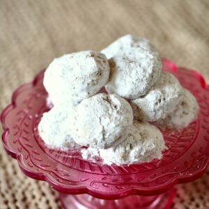 a pink tray of white butter cookies stacked on top.