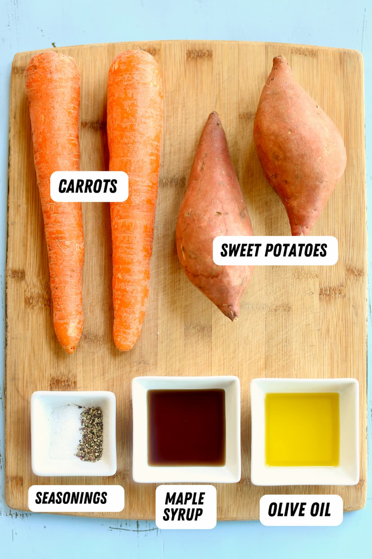 a cutting board of ingredients for a side dish of carrots and sweet potatoes.
