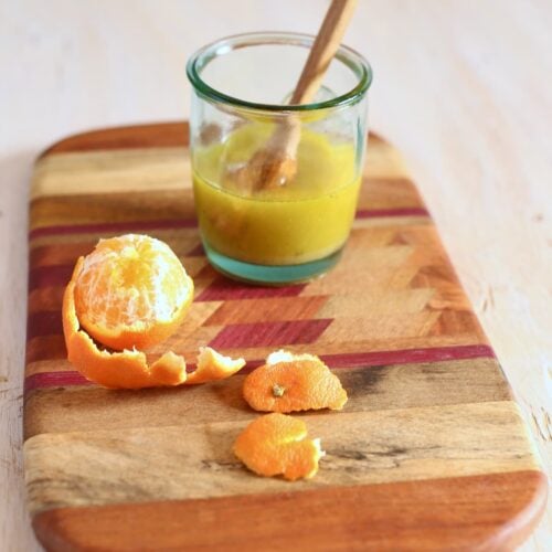 a cutting board of ingredients for salad dressing.