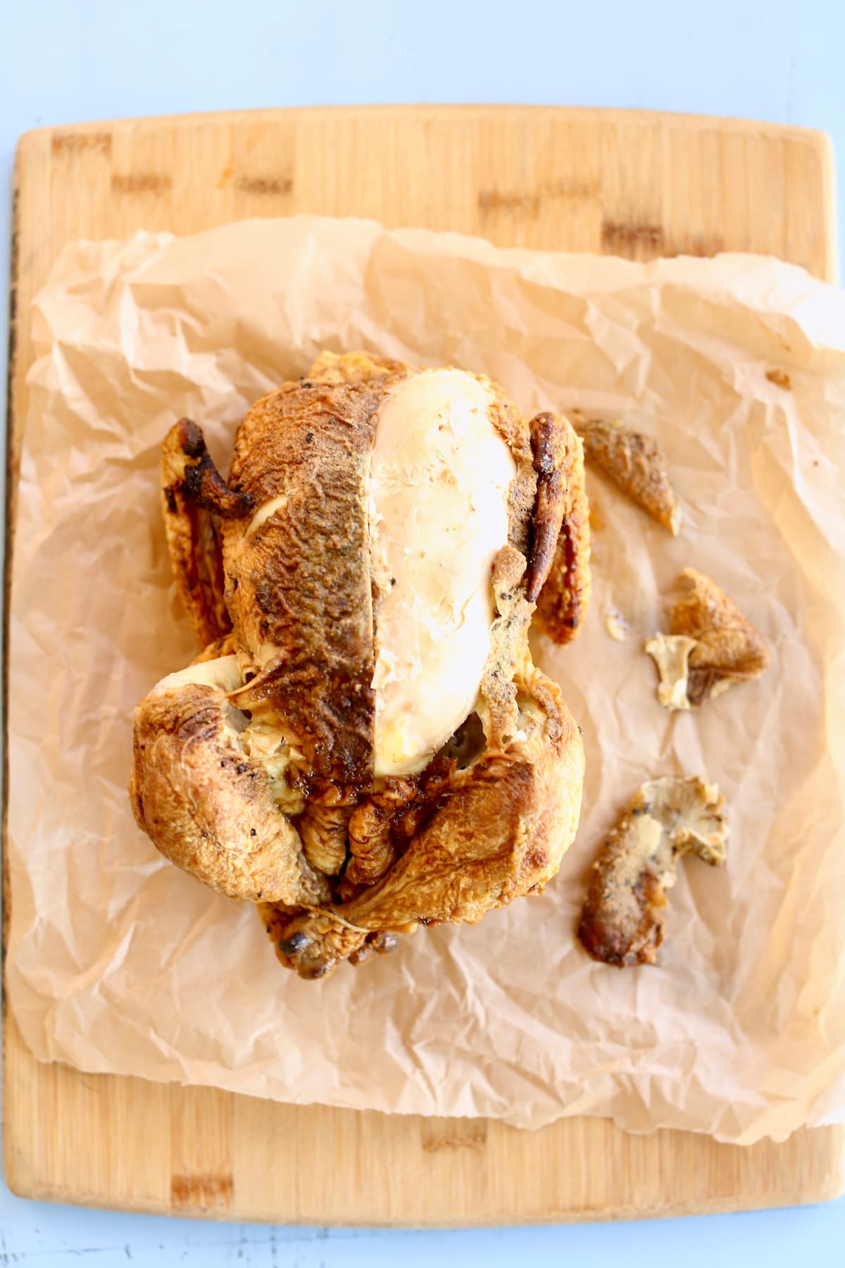 a whole chicken on a piece of parchment paper.