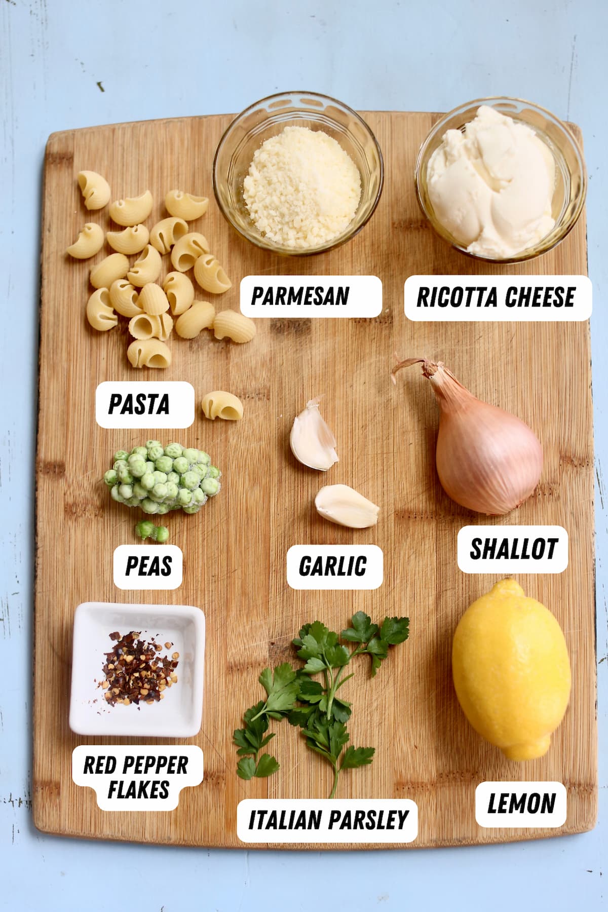 a cutting board of ingredients for pasta.