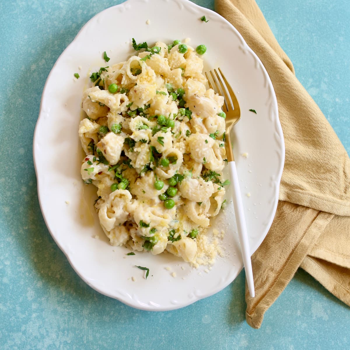 a square photo of pasta on a white plate.