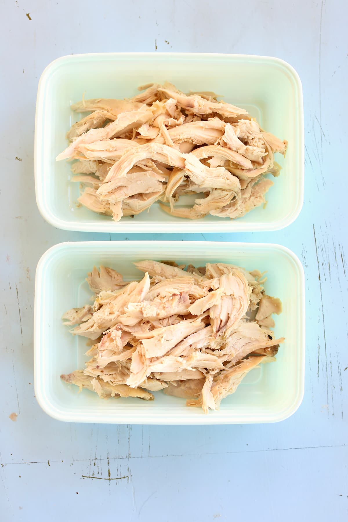 two meal prep containers of shredded chicken.