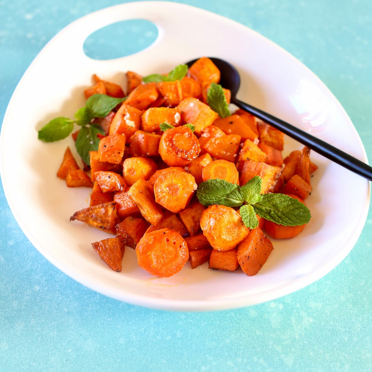 a side view of carrots and potatoes in a white bowl.