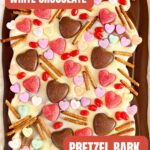 a pinterest image of a chocolate bark with valentines candy in it.