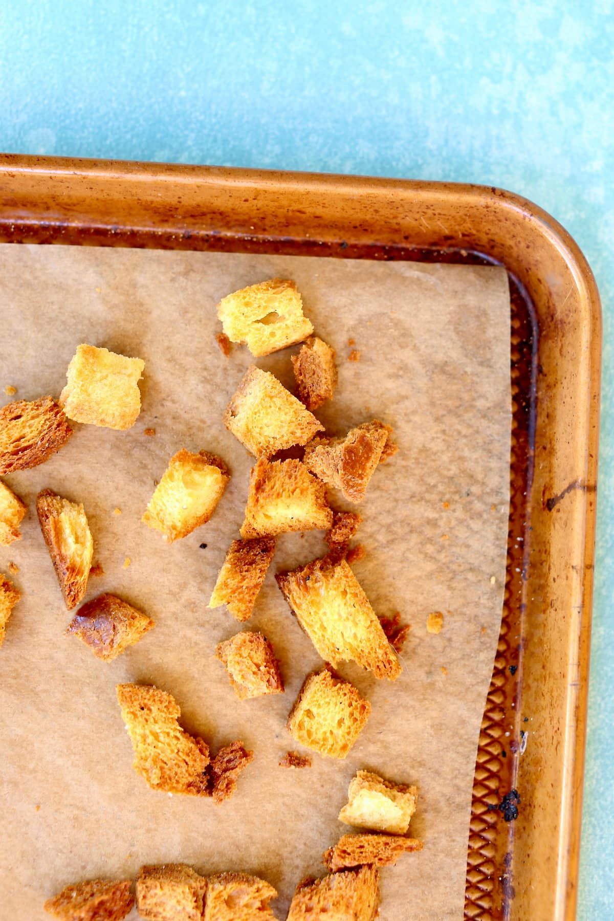 the corner of a baking sheet with croutons on it.