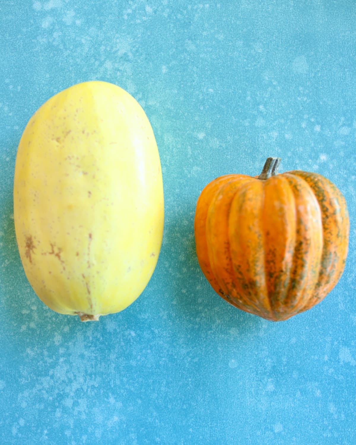 two squash on a blue table.