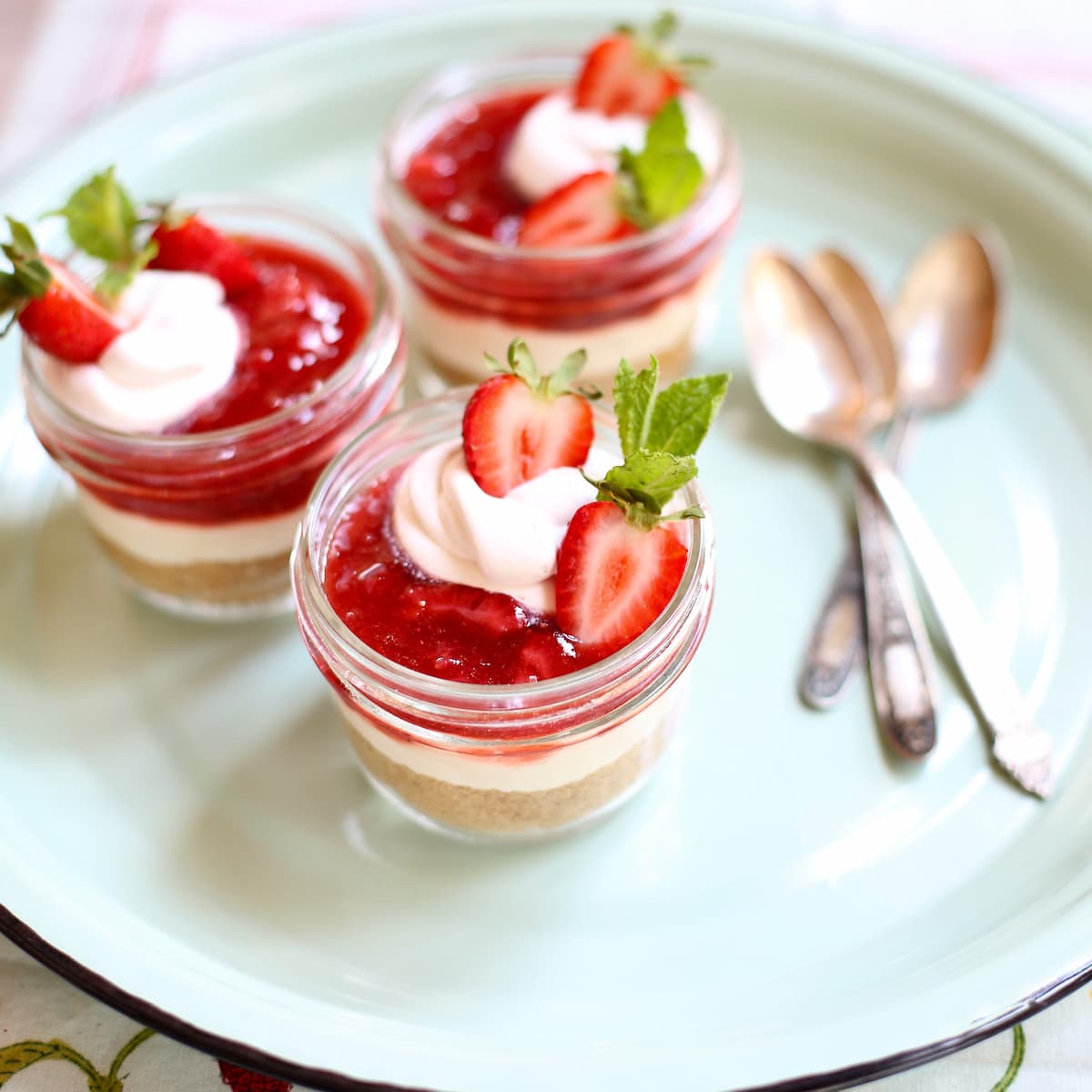 a photo of strawbery cheesecakes on a blue platter.