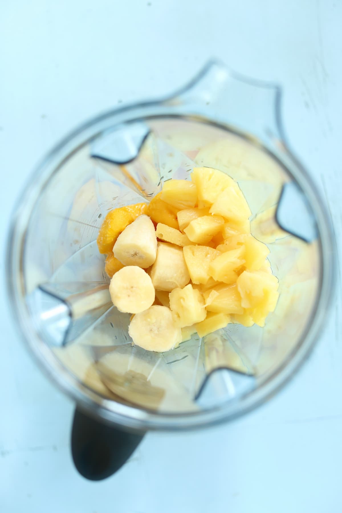 an overhead photo of fruit in a vitamix blender.