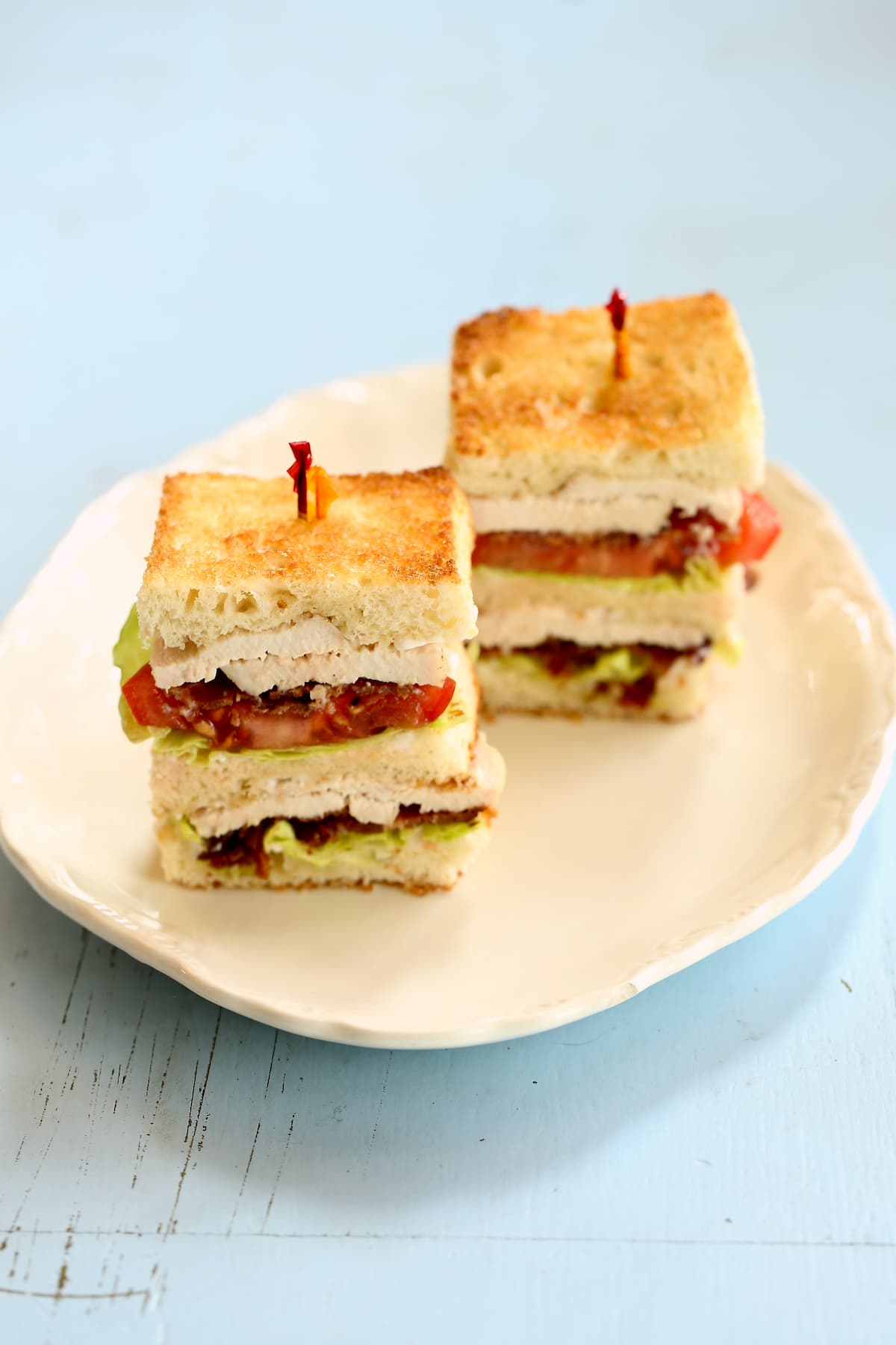 a side photo of a two pieces of club sandwich.