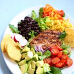 a side view of chicken salad on a white platter with text overlay.