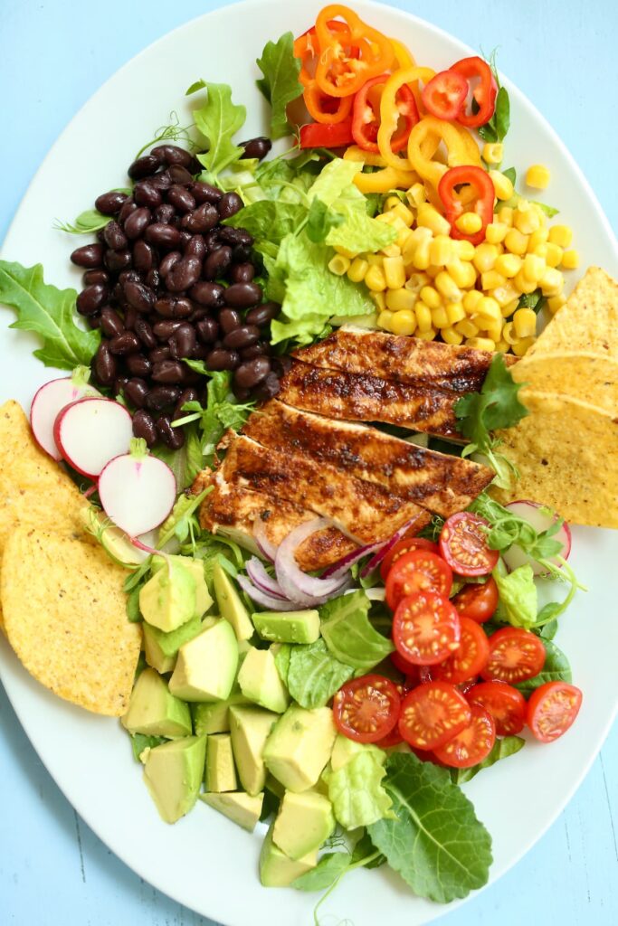 a close up photo of a chicken salad on a white platter.