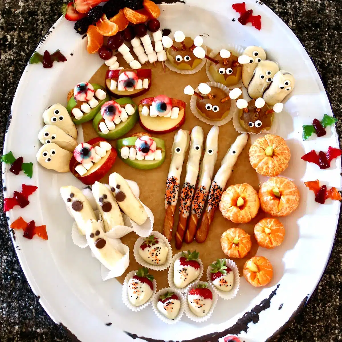 a square overhead image of fruit halloween snacks.