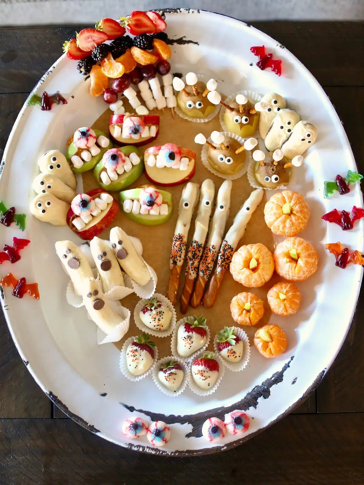 A white tray of assorted easy and fun fruit Halloween snacks.